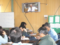 ビデオを観てメモを取っている社員の写真
