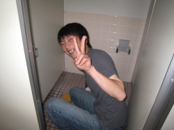便器を掃除しながらピースしている写真