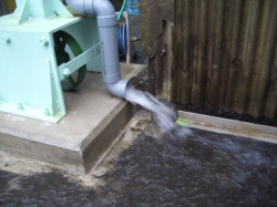 排水管から流れ出る雨の写真