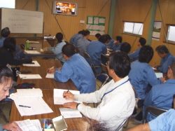 ビデオを熱心に見ている社員の写真