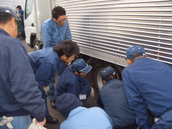 チェーンの手本を見つめる社員の写真