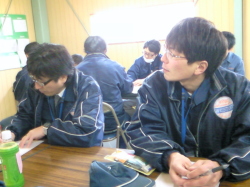 メモを取る社員と話を聞いている社員の写真