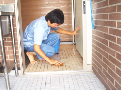 素足でトイレ内の床掃除をしている写真