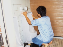 便器をタオルで拭いている写真