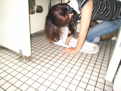 大便器に手を入れて掃除している写真